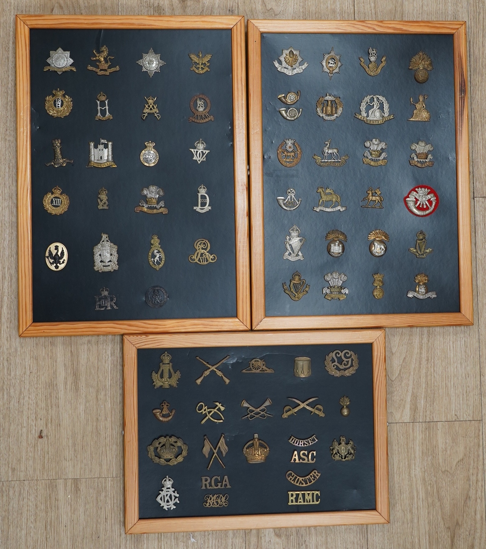 A collection of fifty-eight military cap badges, plus a few shoulder titles, mounted on four boards including; 26th Hussars, Inniskilling Regiment, 3rd Dragoon Guards, the Cheshire Regiment, Loyal North Lancashire, the N